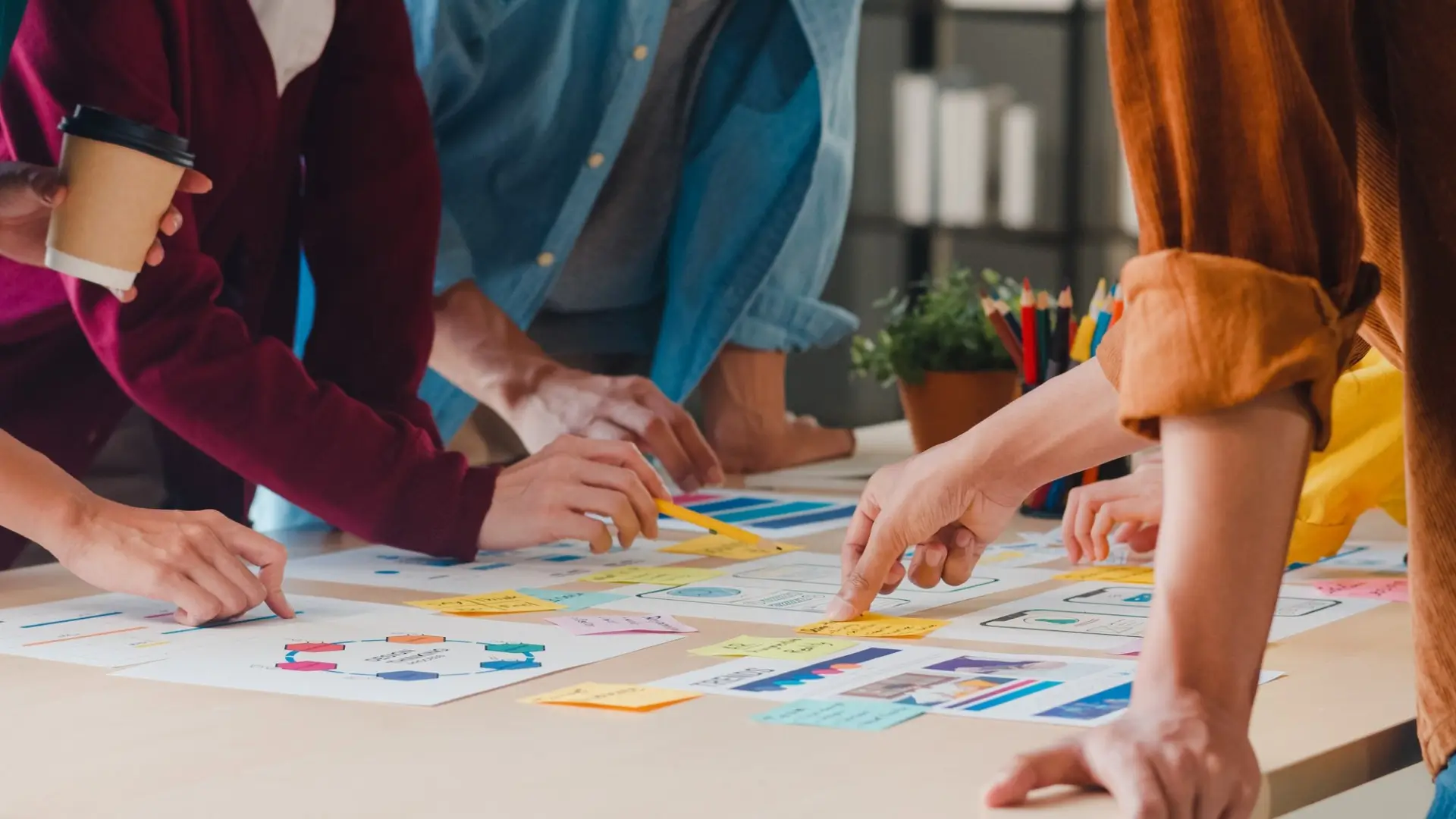 Personas haciendo lluvia de ideas sobre gráficos en una mesa